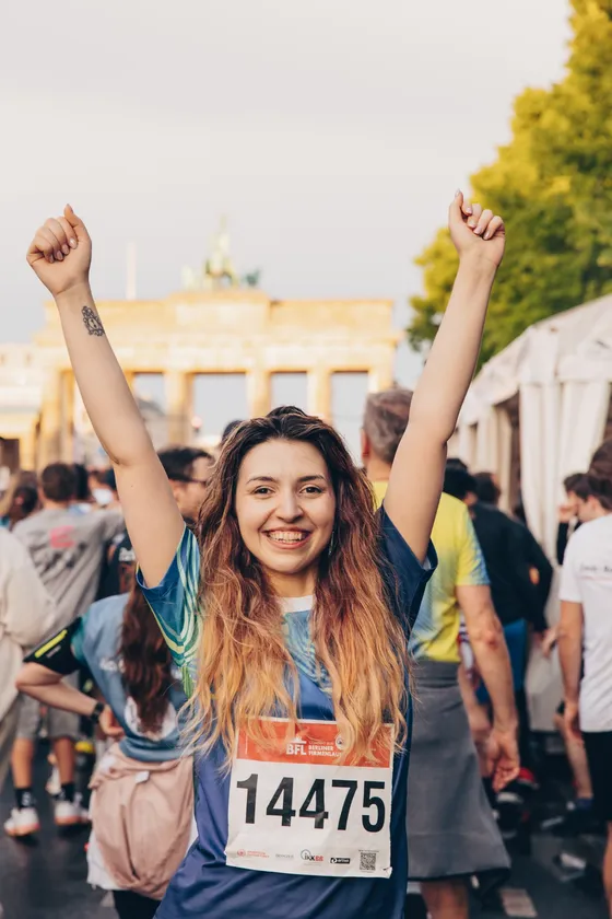 Teilnehmerin nach dem Berliner Firmenlauf vor dem Brandenburger Tor
