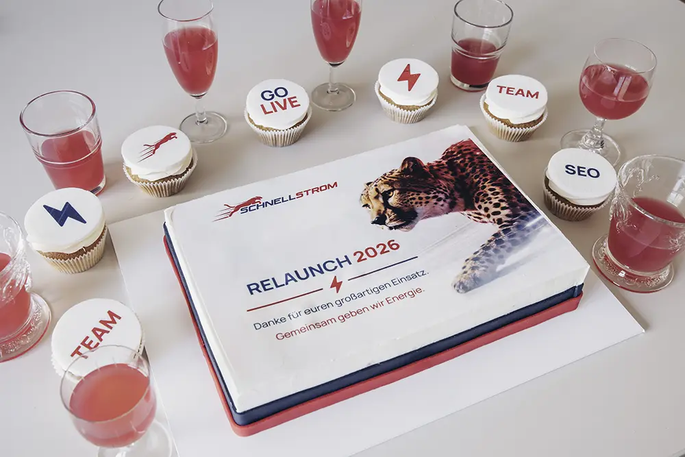 Relaunch-Torte mit Schnellstrom-Logo, Gepard-Motiv und der Aufschrift „Relaunch 2026 – Danke für euren großartigen Einsatz“, ringsum Cupcakes mit den Aufschriften Go Live, Team und SEO